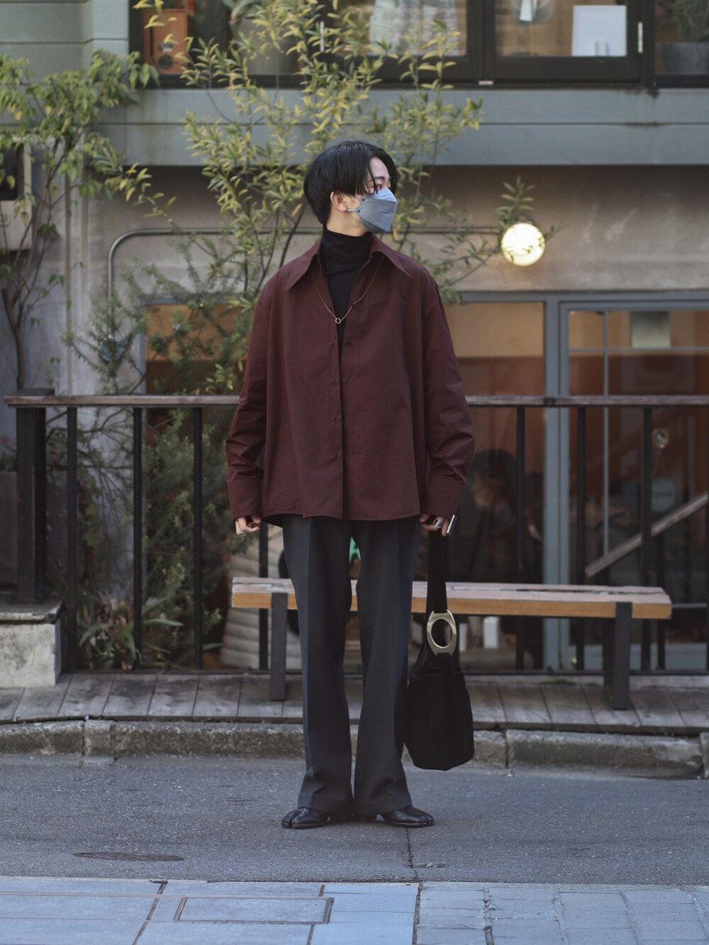 レッド系のシャツ/ブラウス、ブラック系のニット/セーター、ブラック系のスラックスを着用したメンズの冬コーディネートの2枚目の写真