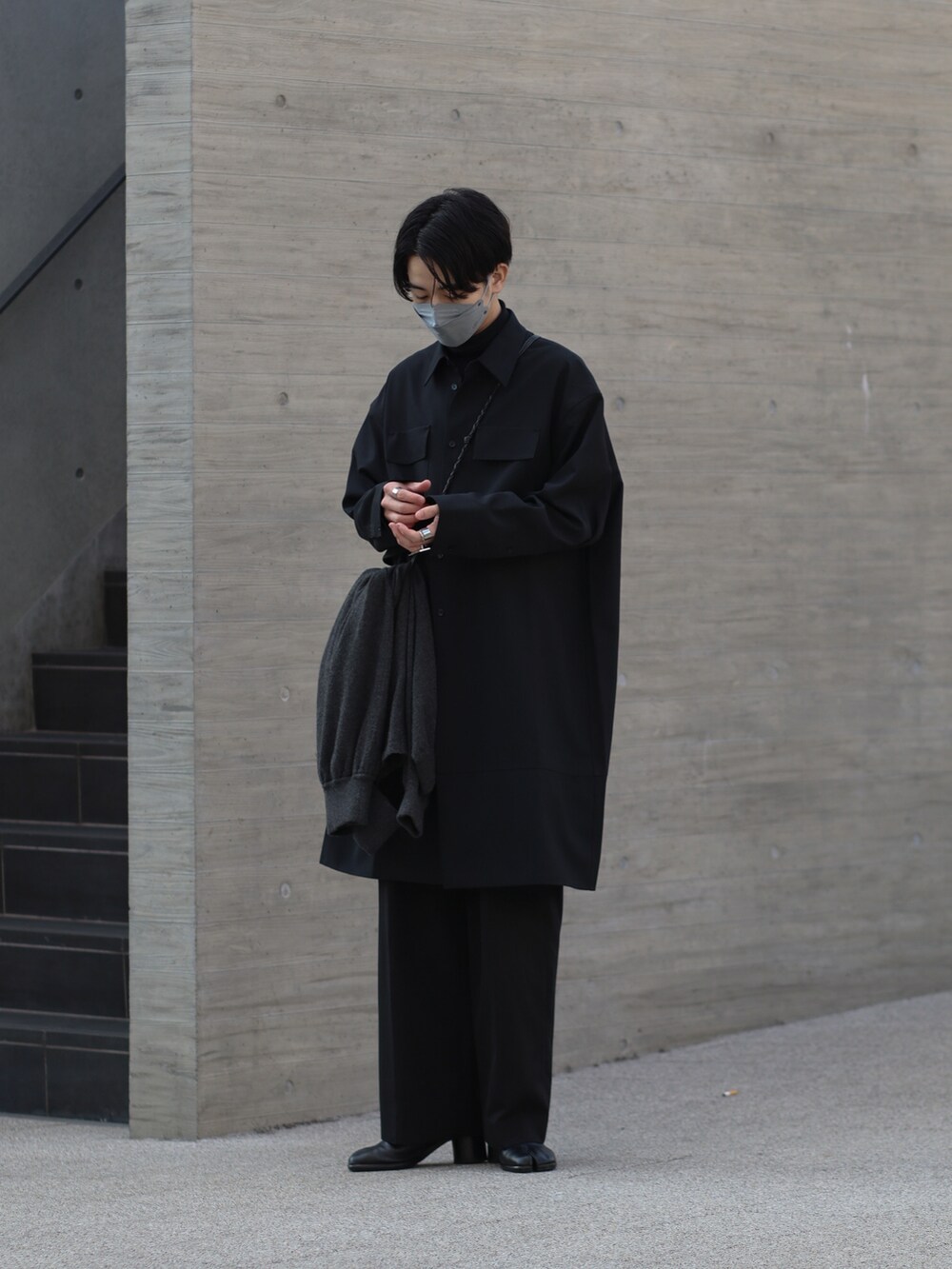 ブラック系のシャツ/ブラウス、グレー系のニット/セーター、ブラック系のスラックスを着用したメンズの冬コーディネートの3枚目の写真