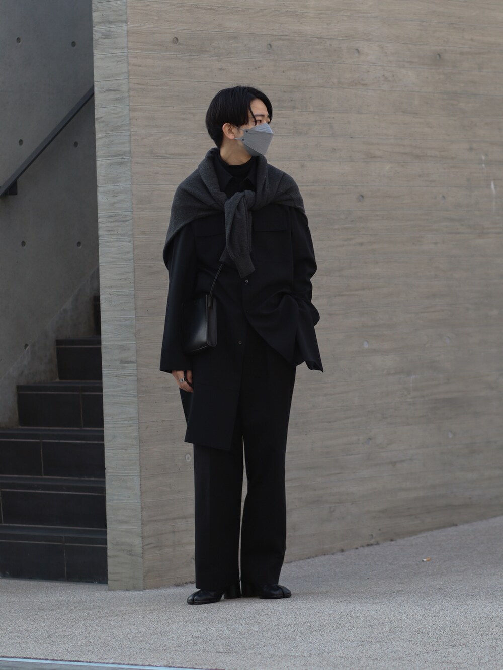 ブラック系のシャツ/ブラウス、グレー系のニット/セーター、ブラック系のスラックスを着用したメンズの冬コーディネートの2枚目の写真