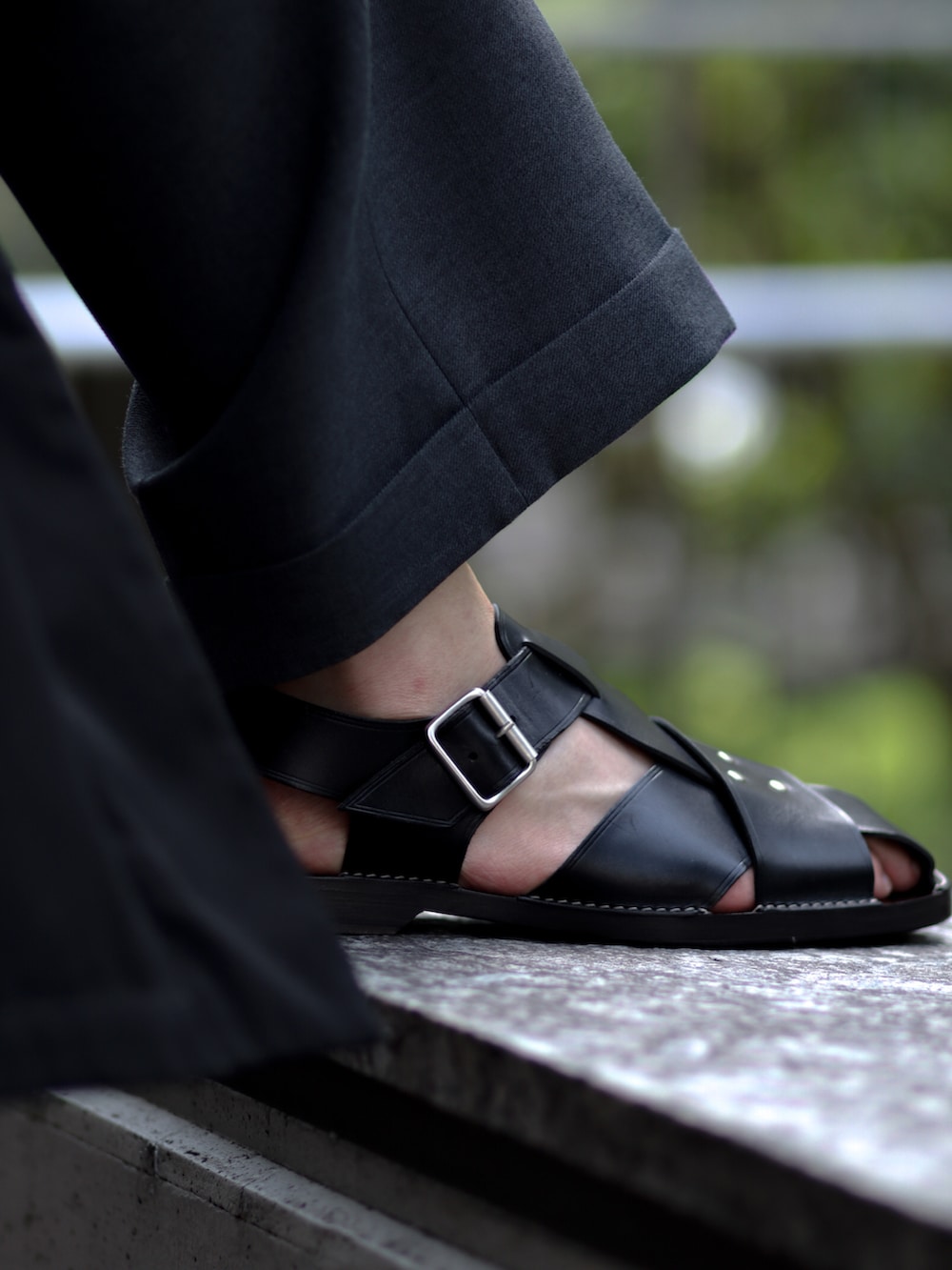 ブラック系のその他アウター、ブラック系のスラックス、ブラック系のサンダルを着用したメンズの春コーディネートの5枚目の写真