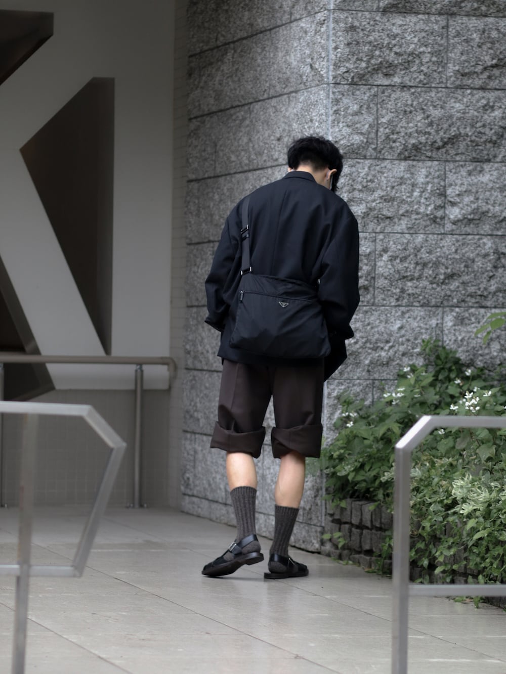 ブラック系のテーラードジャケット、ブラウン系のその他パンツ、ブラック系のサンダルを着用したメンズの夏コーディネートの4枚目の写真