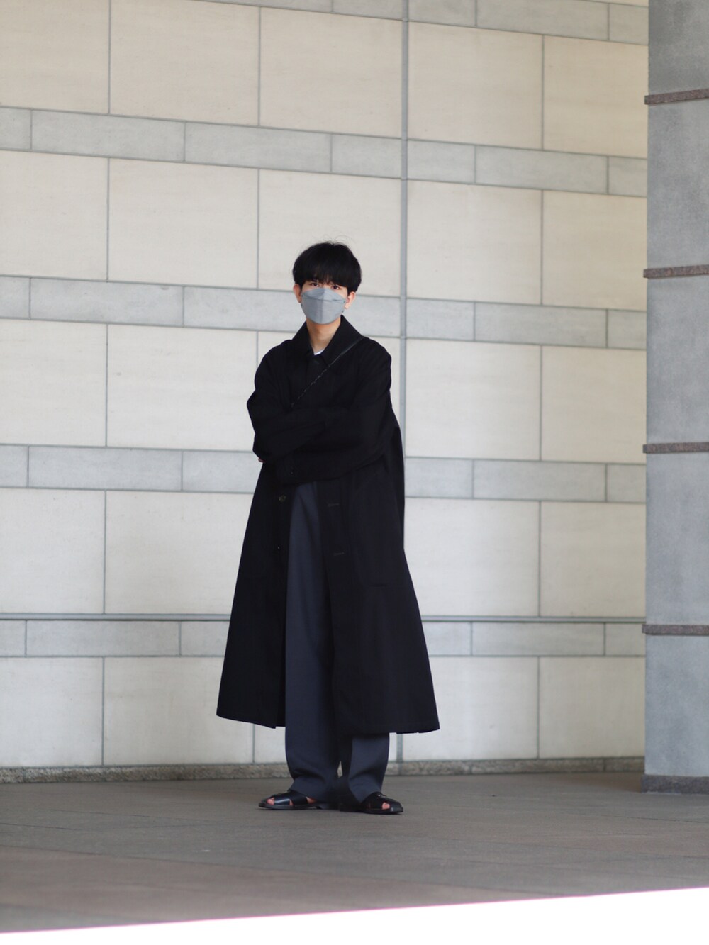 ブラック系のその他アウター、ブラック系のサンダル、ブラック系のスラックスを着用したメンズの春コーディネートの2枚目の写真