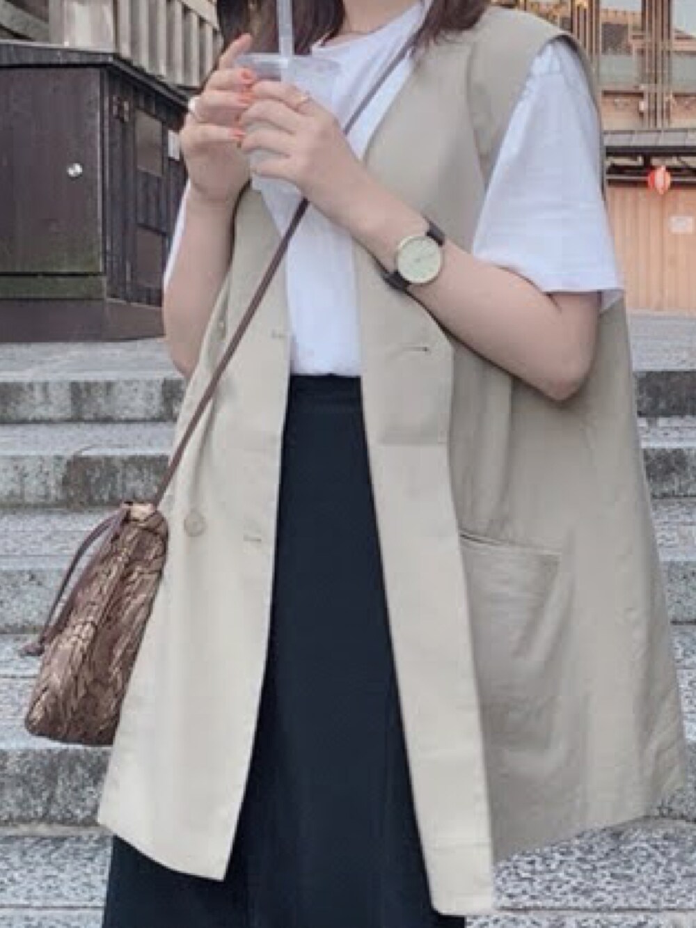 ホワイト系のショルダーバッグ、ブラック系のスカート、ホワイト系のTシャツ/カットソーを着用したレディースの冬コーディネートの2枚目の写真