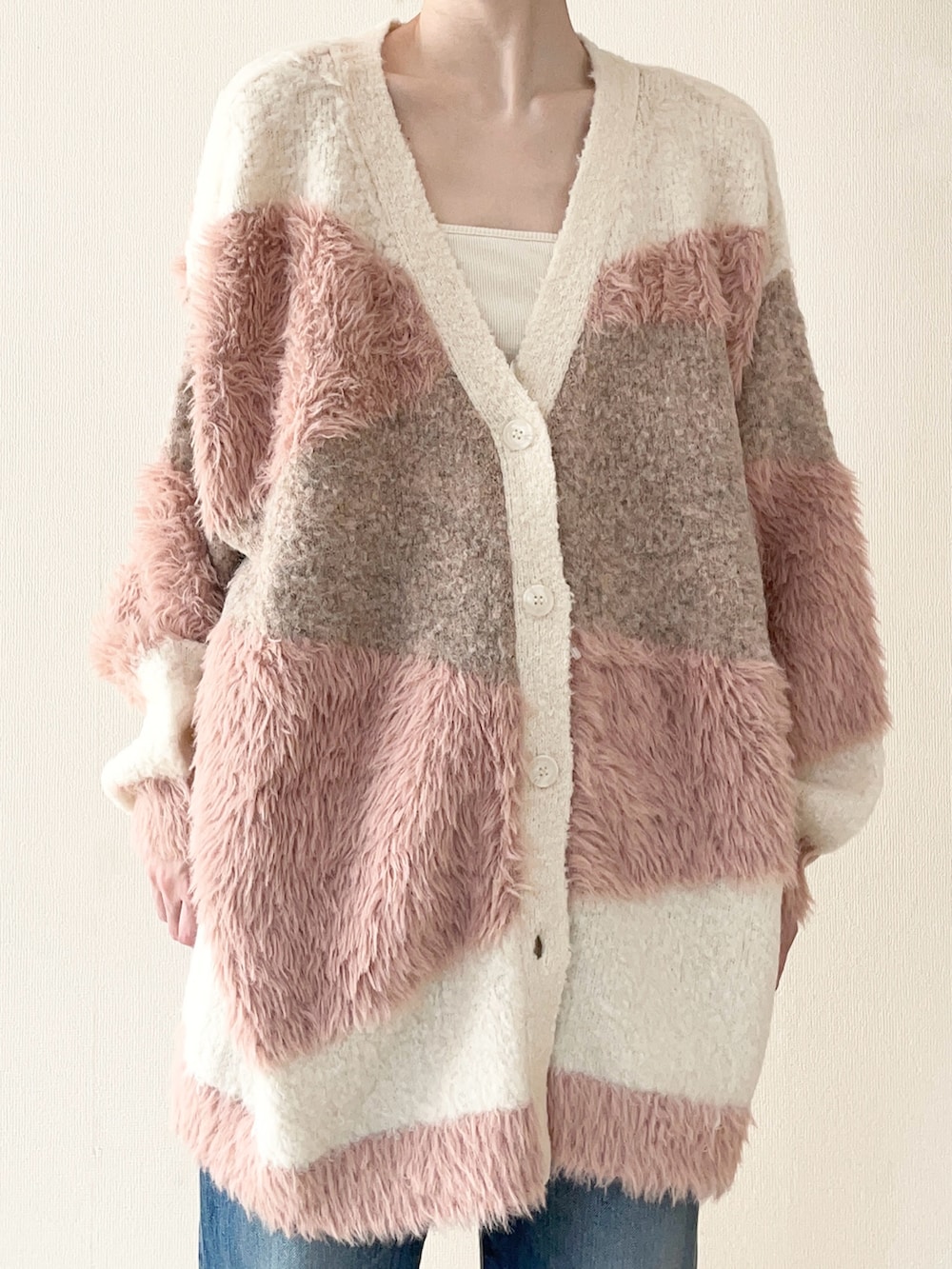 ホワイト系のカーディガン/ボレロ、ホワイト系のスニーカー、ブルー系のデニムパンツを着用したレディースの秋コーディネートの3枚目の写真