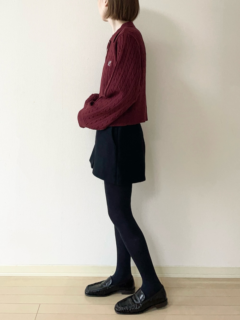 レッド系のニット/セーター、ブラック系のその他パンツ、ブラウン系のローファーを着用したレディースの秋コーディネートの2枚目の写真