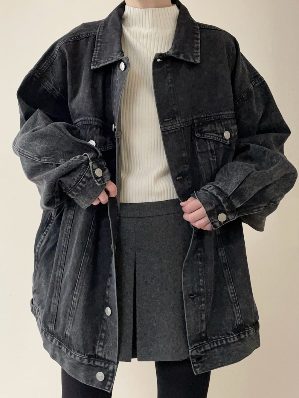 ブラック系のデニムジャケット、ブラウン系のローファー、ホワイト系のニット/セーターを着用したレディースの冬コーディネートの3枚目の写真