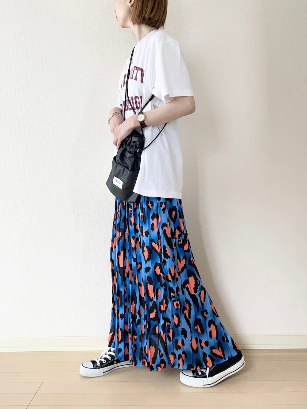 ブラック系のTシャツ/カットソー、ブルー系のスカート、ブラック系のスニーカーを着用したレディースの夏コーディネートの2枚目の写真