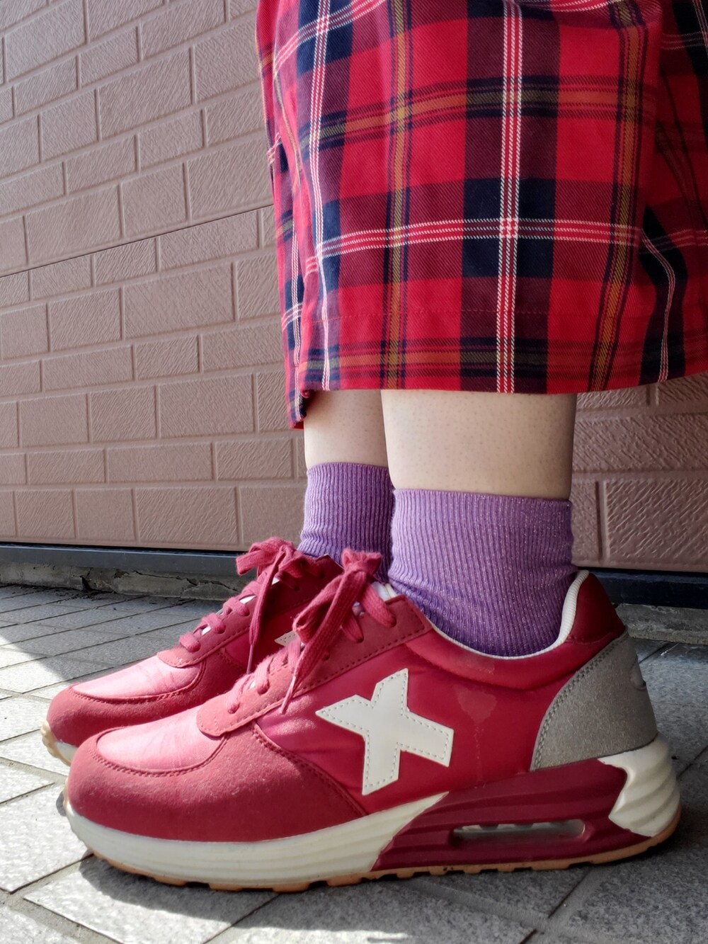 ベージュ系のスウェット、レッド系のスカート、レッド系のスニーカーを着用したレディースの春コーディネートの2枚目の写真