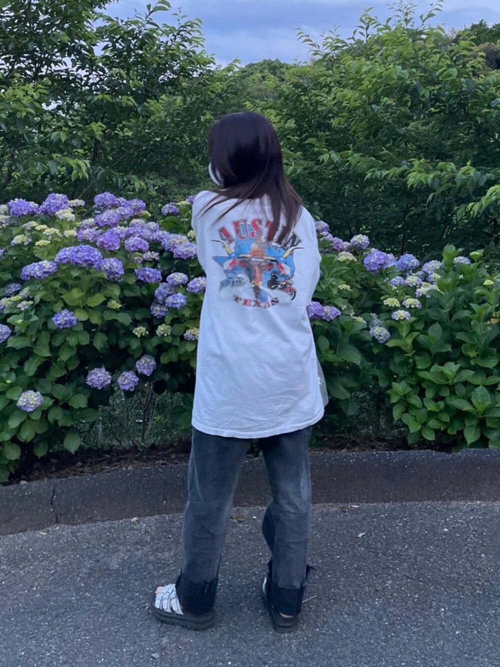 ホワイト系のTシャツ/カットソー、ブラック系のデニムパンツ、ホワイト系のサンダルを着用したレディースの夏コーディネートの2枚目の写真