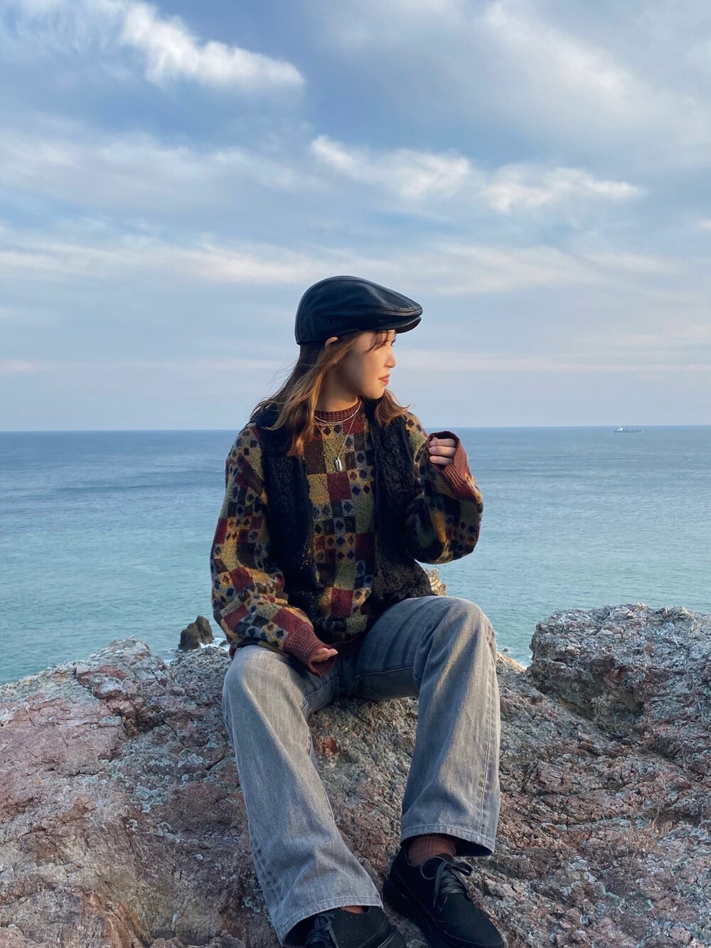 ブラック系のシューズ、グレー系のデニムパンツ、その他のニット/セーターを着用したレディースの秋コーディネートの2枚目の写真