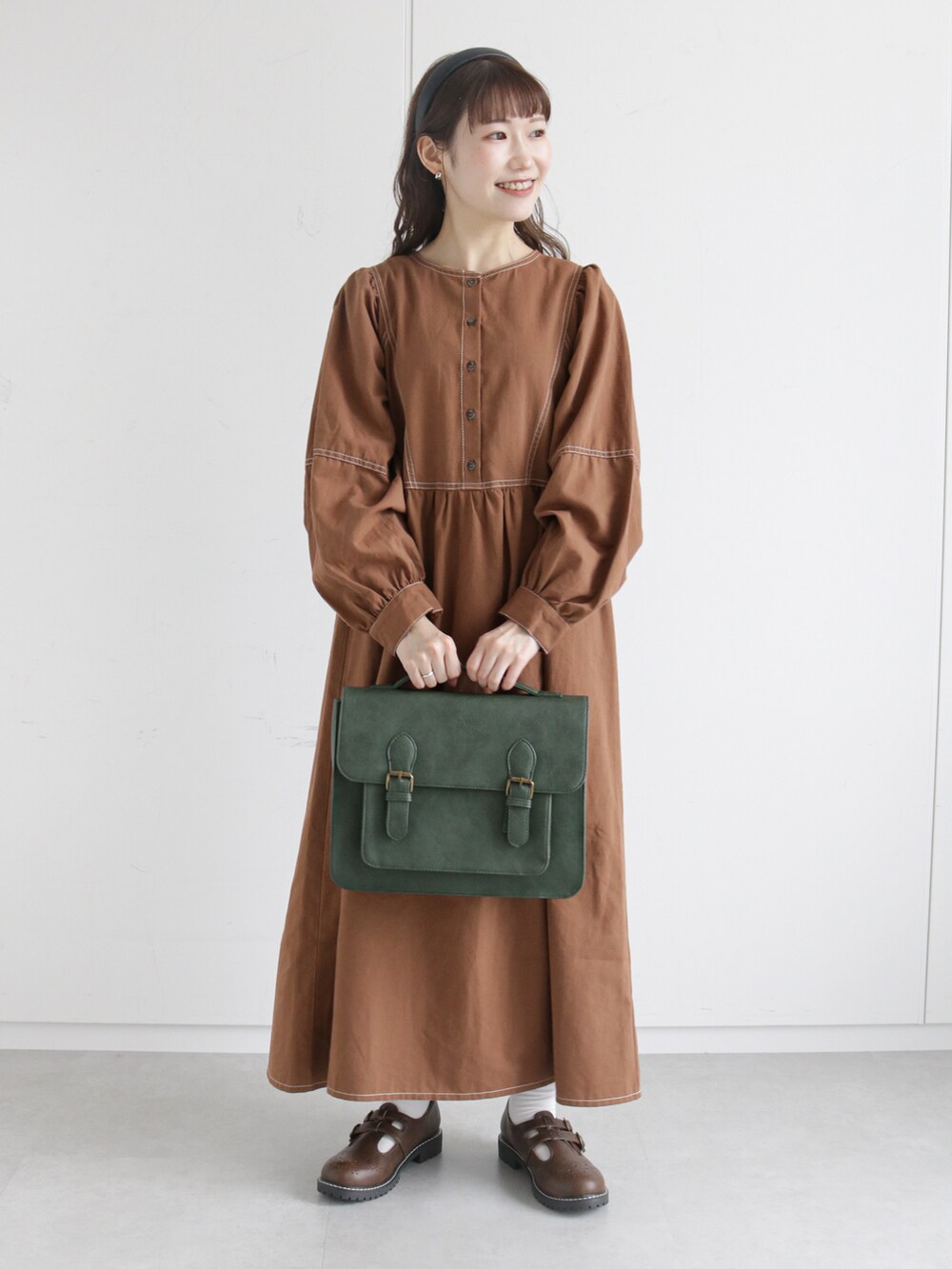 グリーン系のショルダーバッグ、ブラウン系のその他シューズ、グリーン系のベストを着用したレディースの秋コーディネートの2枚目の写真