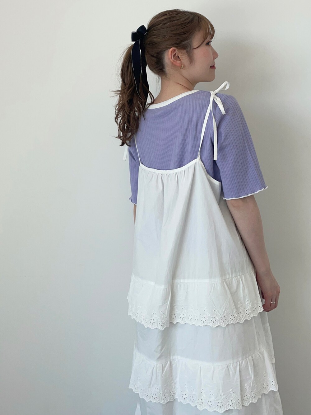 ホワイト系のワンピース、ブルー系のTシャツ/カットソー、グレー系のスニーカーを着用したレディースの春コーディネートの3枚目の写真