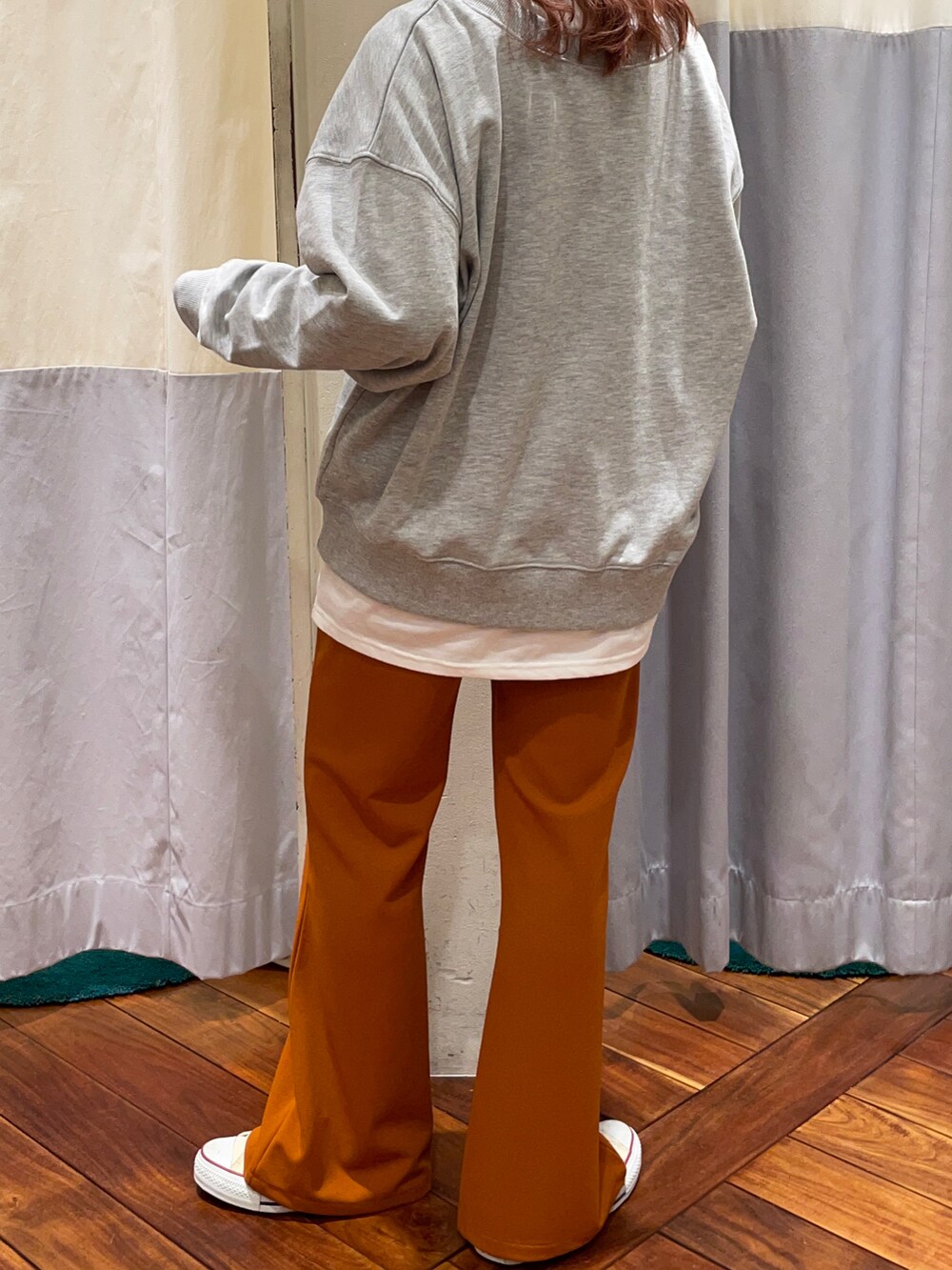 グレー系のスウェット、ホワイト系のTシャツ/カットソー、オレンジ系のパンツを着用したレディースの冬コーディネートの4枚目の写真