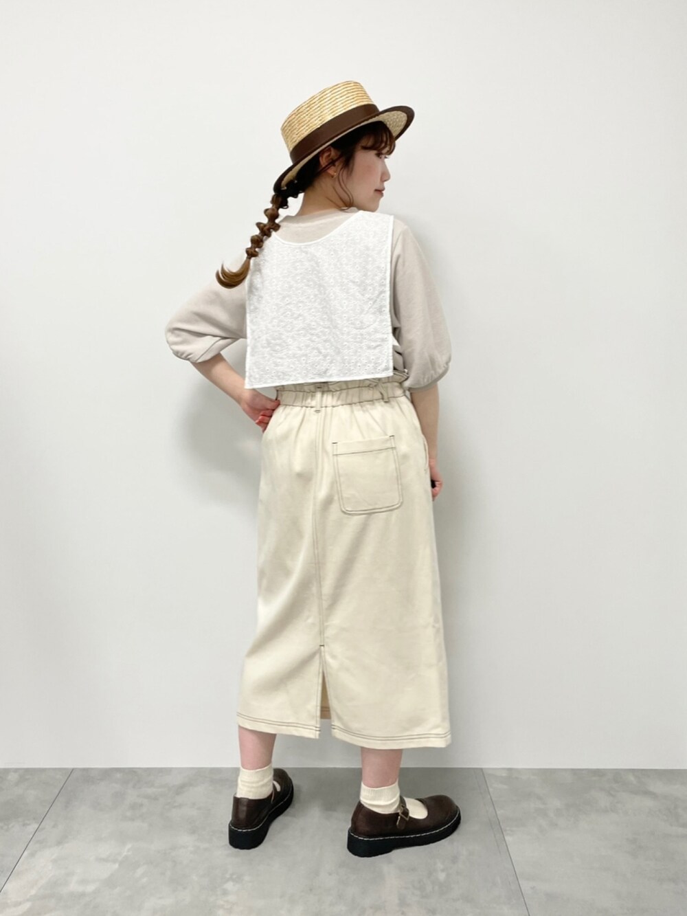 ホワイト系のスカート、ベージュ系のTシャツ/カットソー、グレー系のワンピースを着用したレディースの春コーディネートの2枚目の写真