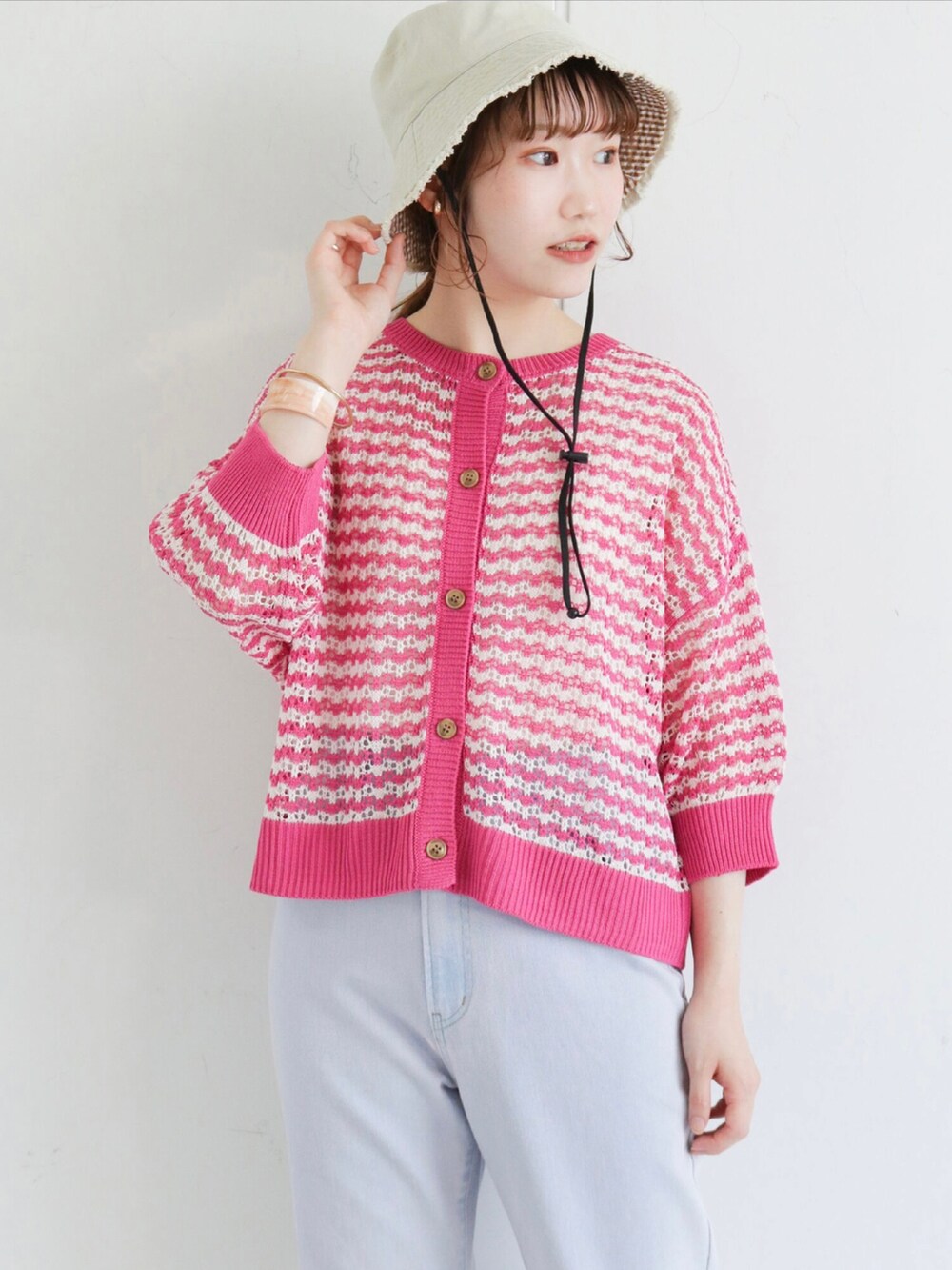 ピンク系のカーディガン/ボレロ、ブルー系のデニムパンツ、ブラック系のサンダルを着用したレディースの春コーディネートの2枚目の写真