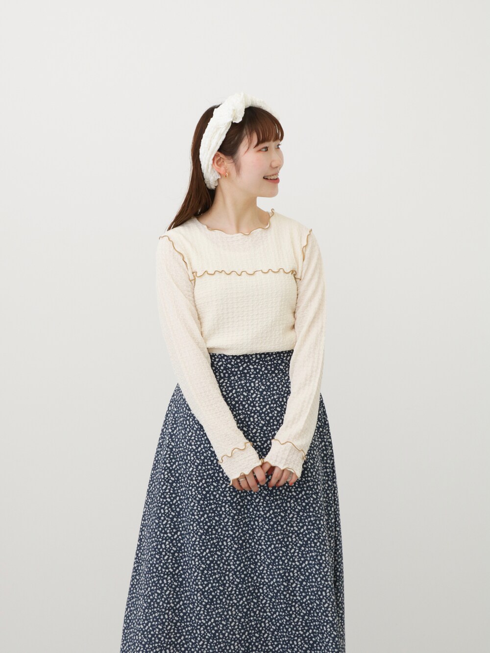 ブラウン系のその他シューズ、グリーン系のベスト、ブルー系のスカートを着用したレディースの春コーディネートの3枚目の写真