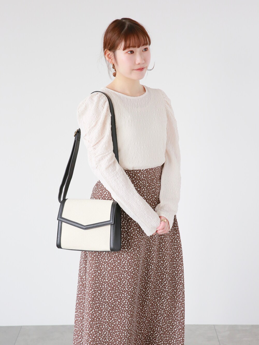 ブラック系のその他シューズ、ブラック系のハンドバッグ、ホワイト系のTシャツ/カットソーを着用したレディースの春コーディネートの2枚目の写真