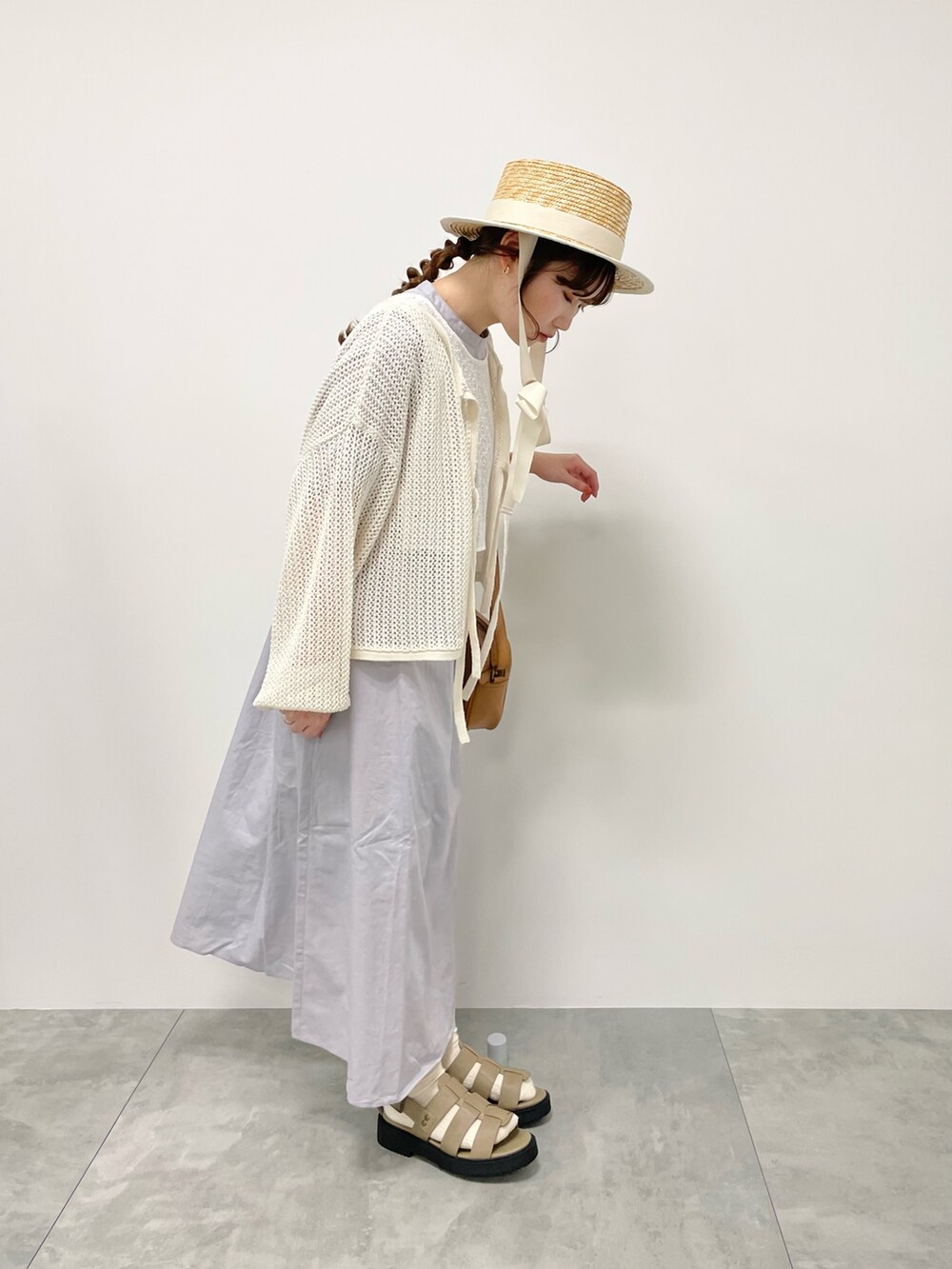 グレー系のワンピース、ホワイト系のカーディガン/ボレロ、ホワイト系のハットを着用したレディースの春コーディネートの2枚目の写真