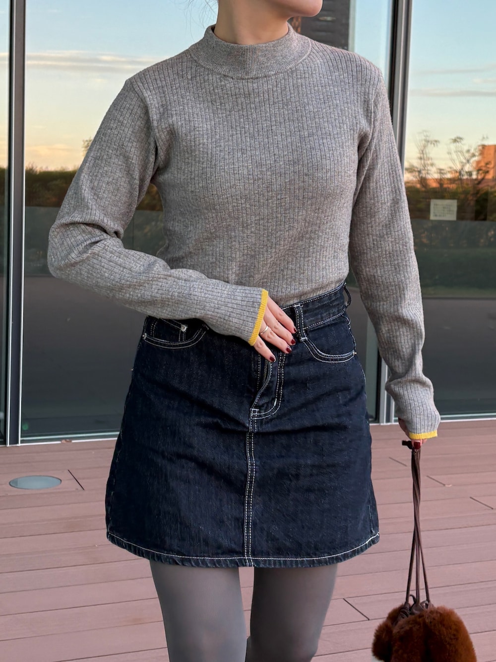 グレー系のニット/セーター、ブラック系のスニーカーを着用したレディースの秋コーディネートの4枚目の写真