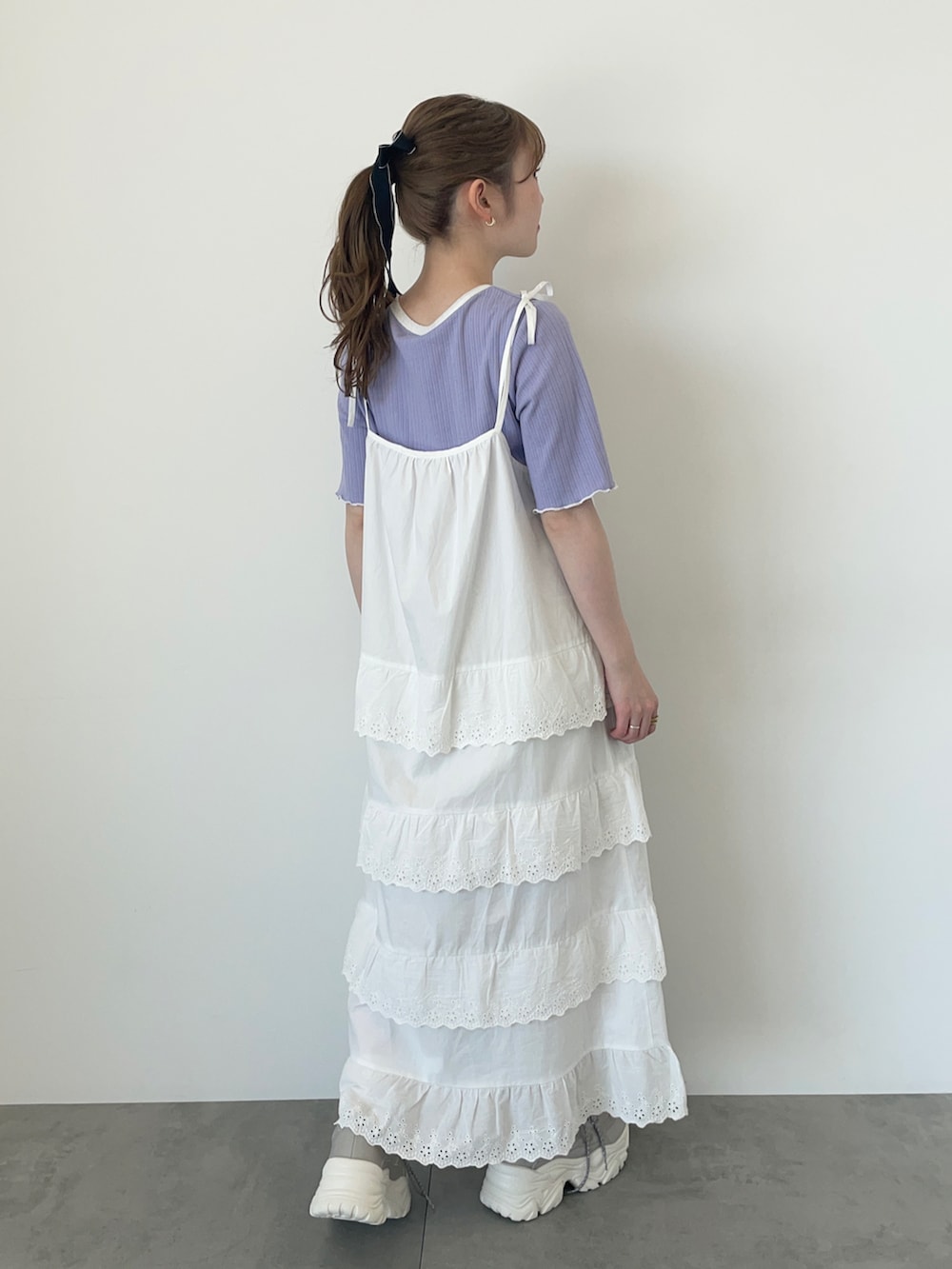 ホワイト系のワンピース、ブルー系のTシャツ/カットソー、グレー系のスニーカーを着用したレディースの春コーディネートの2枚目の写真