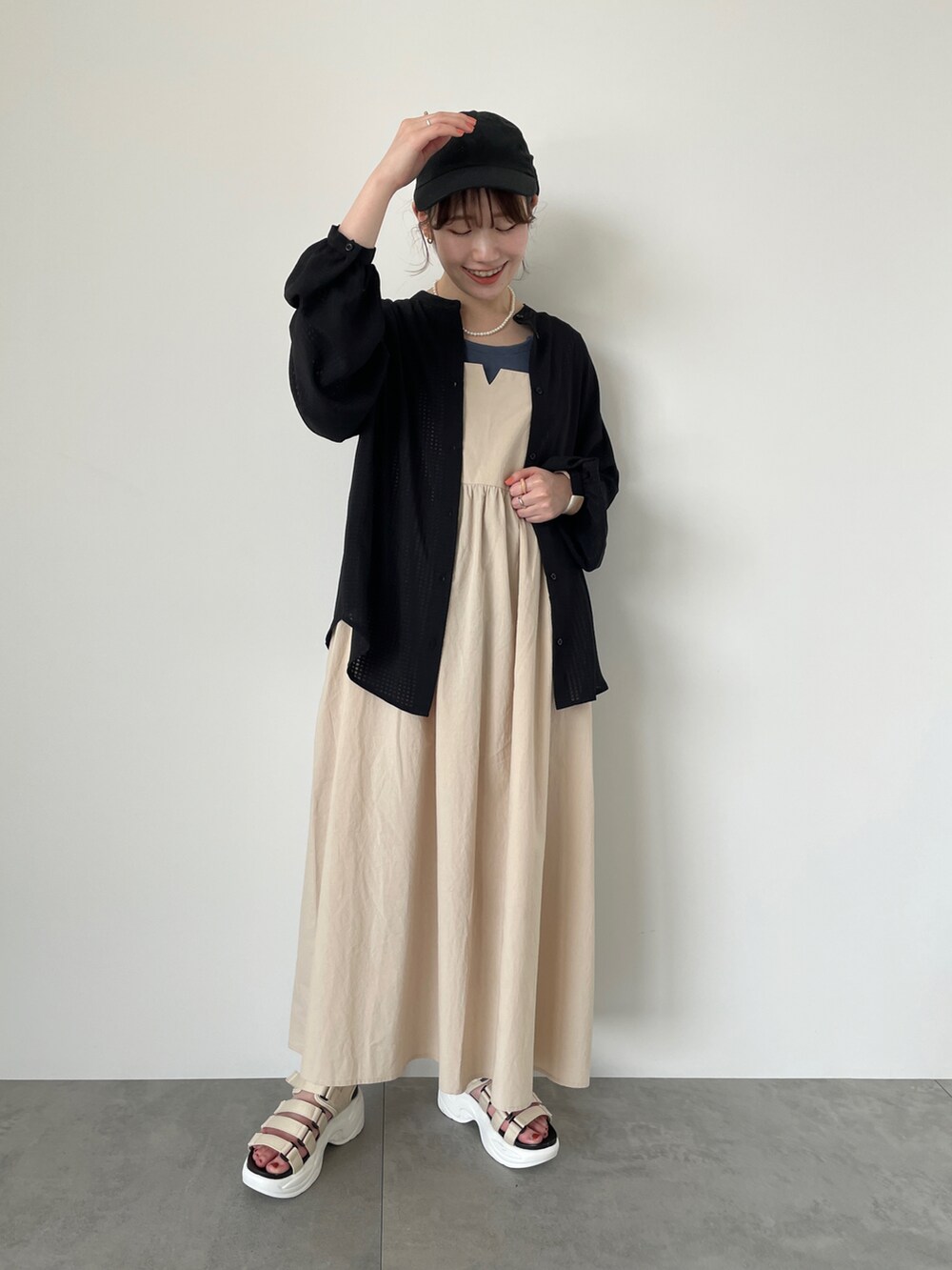 ブラック系のシャツ/ブラウス、ベージュ系のワンピース、グレー系のタンクトップを着用したレディースの春コーディネートの2枚目の写真
