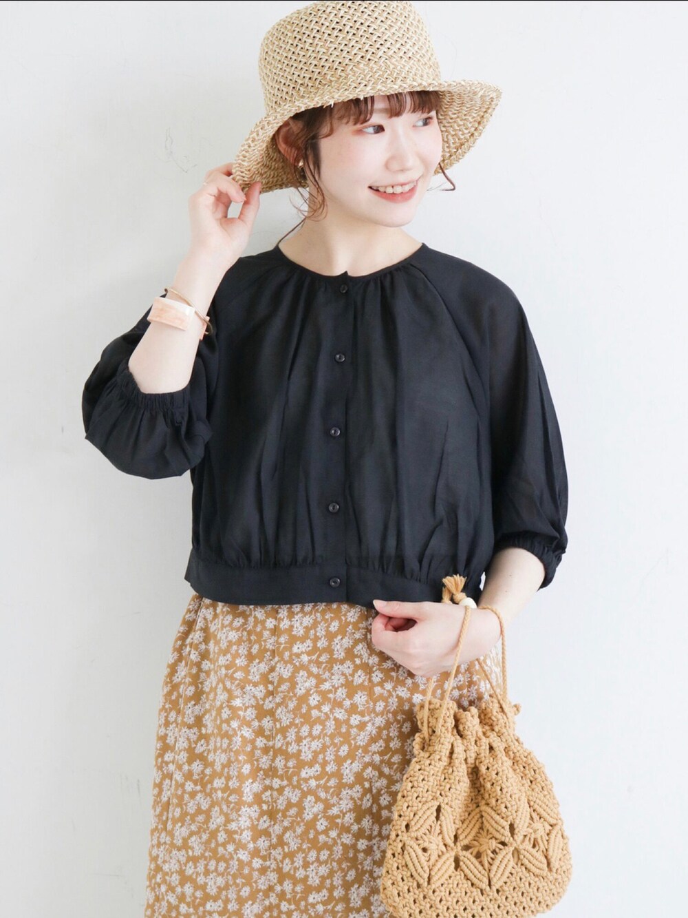 ブラック系のシャツ/ブラウス、ベージュ系のショルダーバッグ、ベージュ系のスカートを着用したレディースの春コーディネートの2枚目の写真