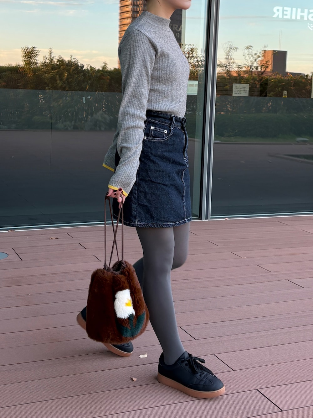 グレー系のニット/セーター、ブラック系のスニーカーを着用したレディースの秋コーディネートの2枚目の写真