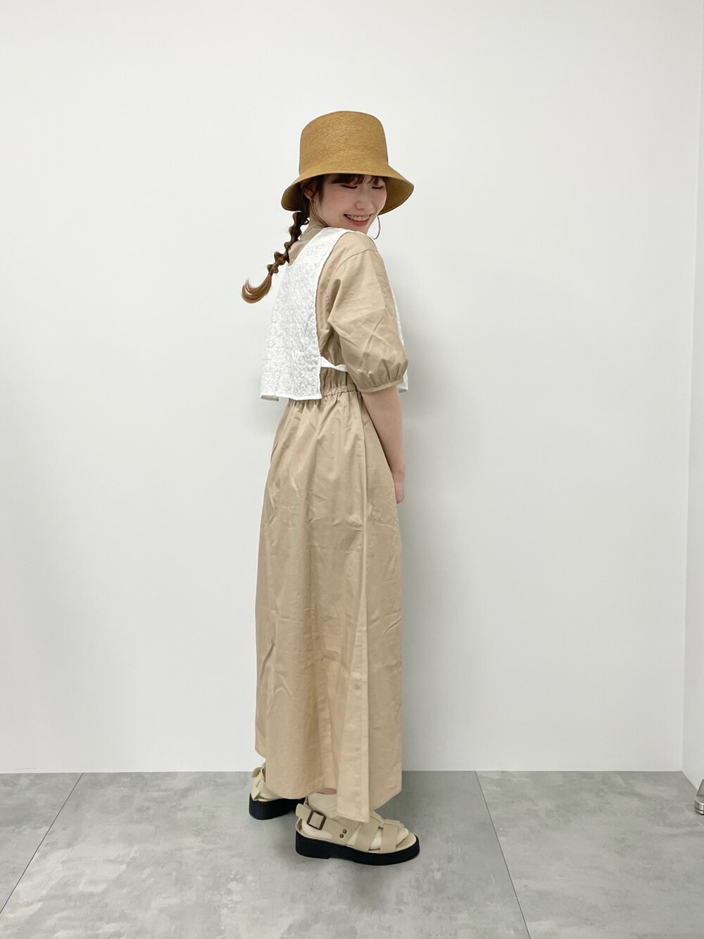 ベージュ系のサンダル、ベージュ系のワンピース、ホワイト系のハンドバッグを着用したレディースの春コーディネートの2枚目の写真