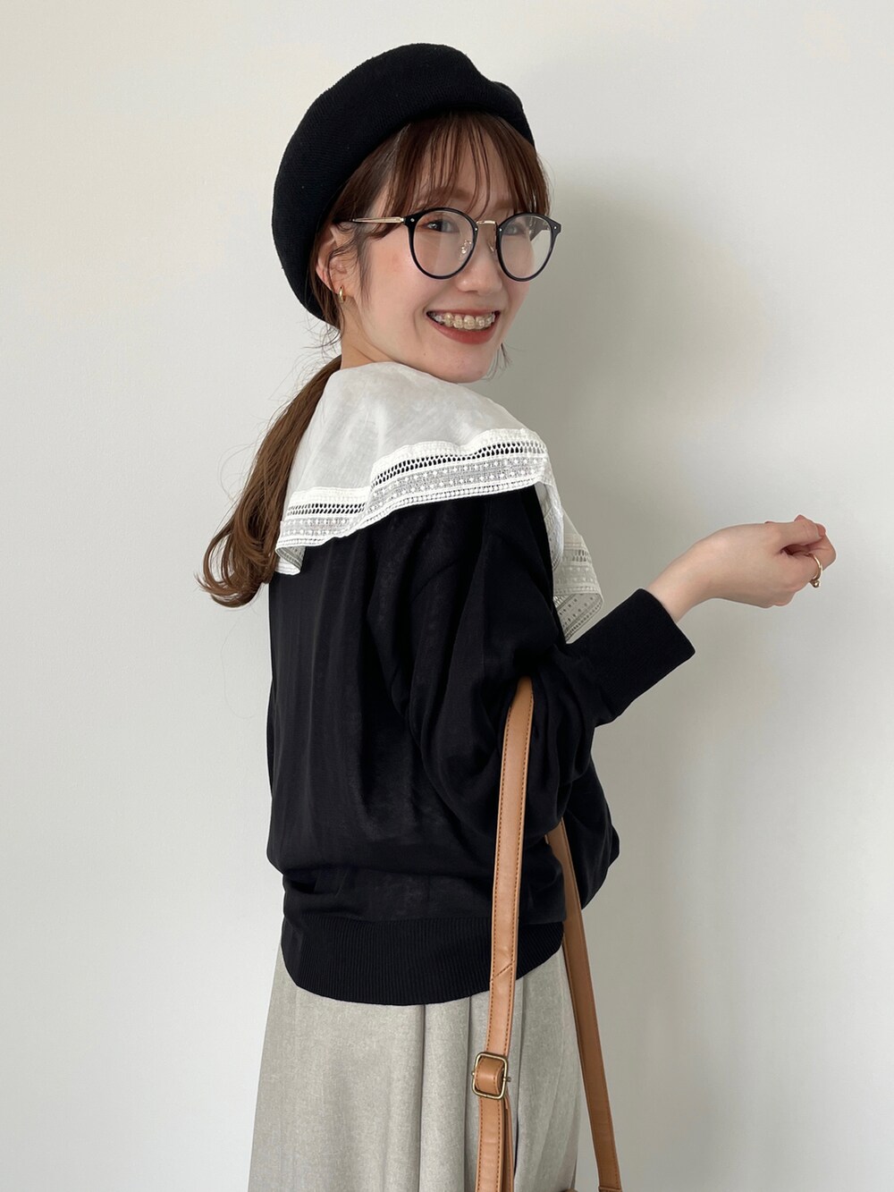 ホワイト系のシャツ/ブラウス、ブラック系のカーディガン/ボレロ、ベージュ系のスカートを着用したレディースの春コーディネートの3枚目の写真