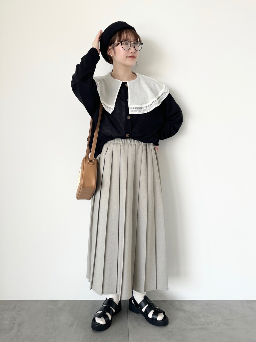 ホワイト系のシャツ/ブラウス、ブラック系のカーディガン/ボレロ、ベージュ系のスカートを着用したレディースの春コーディネートの2枚目の写真