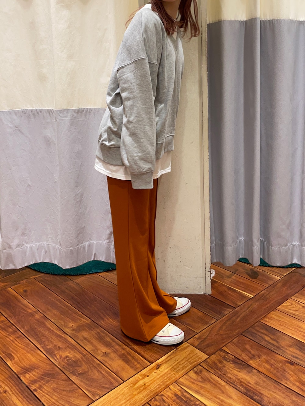 グレー系のスウェット、ホワイト系のTシャツ/カットソー、オレンジ系のパンツを着用したレディースの冬コーディネートの3枚目の写真