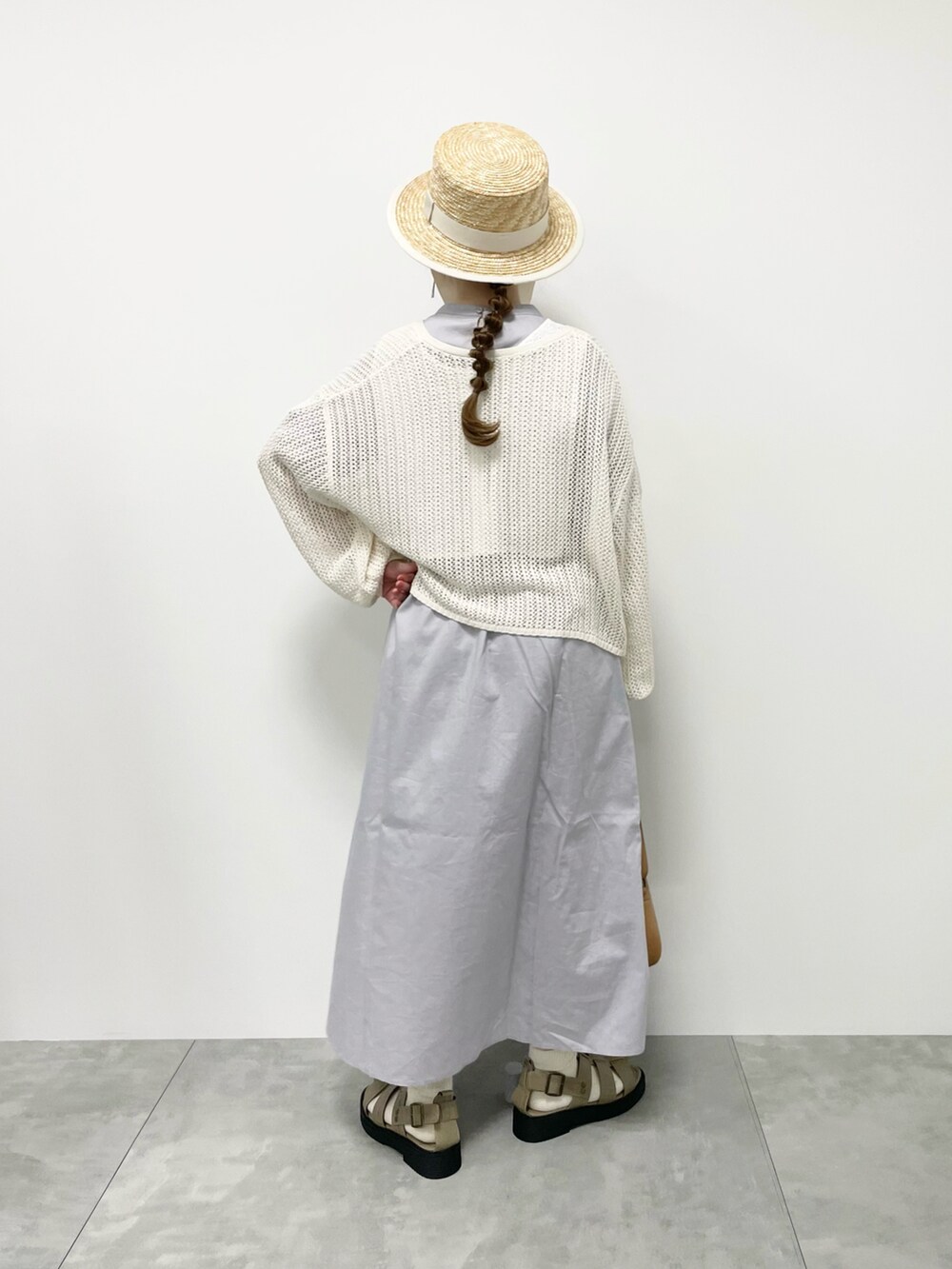 グレー系のワンピース、ホワイト系のカーディガン/ボレロ、ホワイト系のハットを着用したレディースの春コーディネートの3枚目の写真