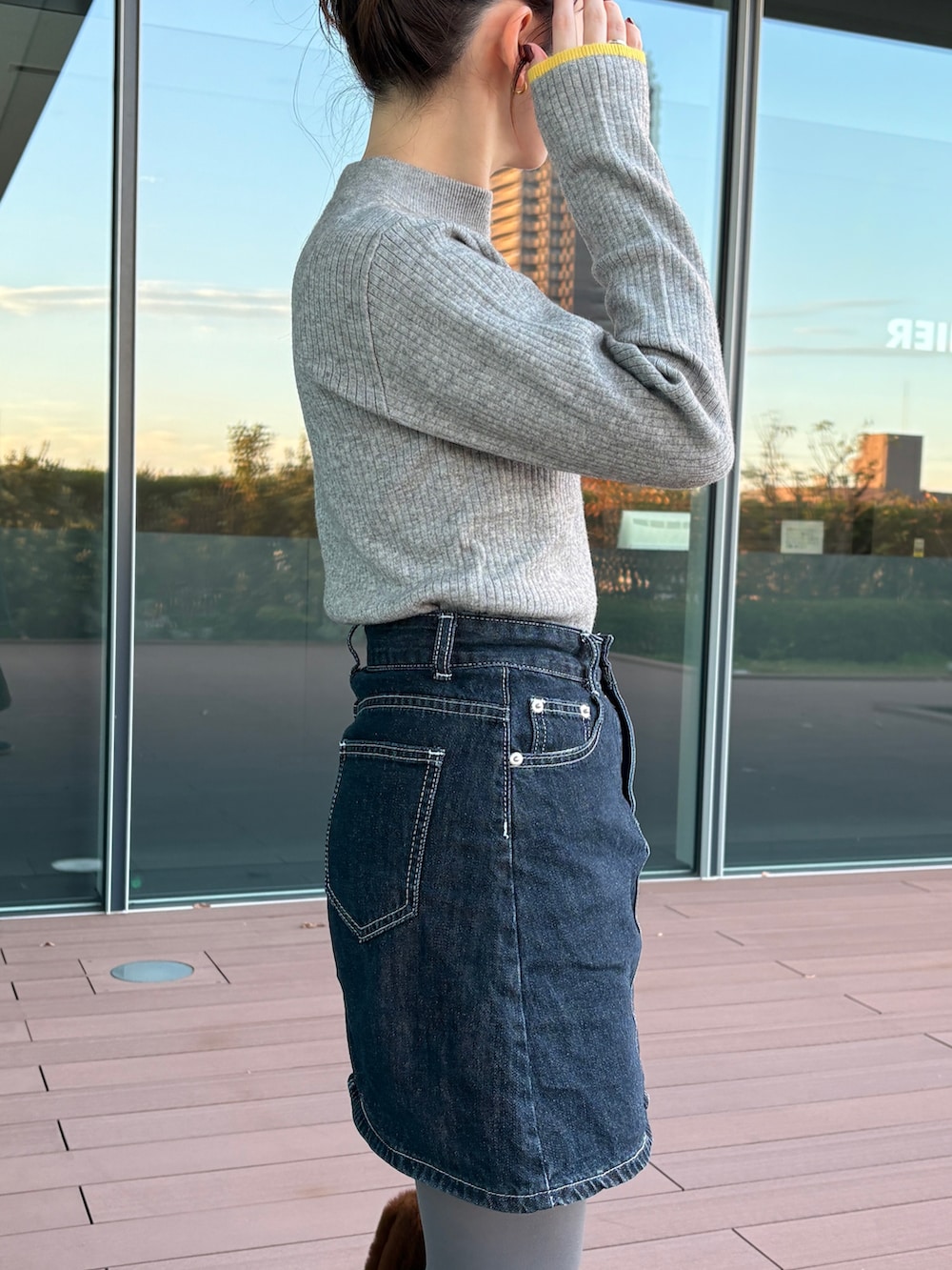 グレー系のニット/セーター、ブラック系のスニーカーを着用したレディースの秋コーディネートの5枚目の写真