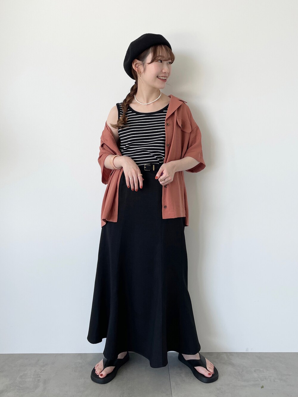 ブラック系のタンクトップ、オレンジ系のシャツ/ブラウス、ブラック系のスカートを着用したレディースの夏コーディネートの3枚目の写真