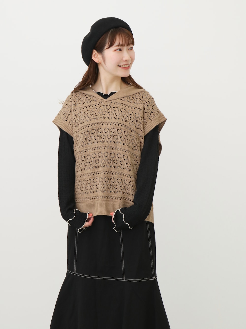 ベージュ系のベスト、ブラック系のスカート、ブラック系のその他シューズを着用したレディースの春コーディネートの2枚目の写真