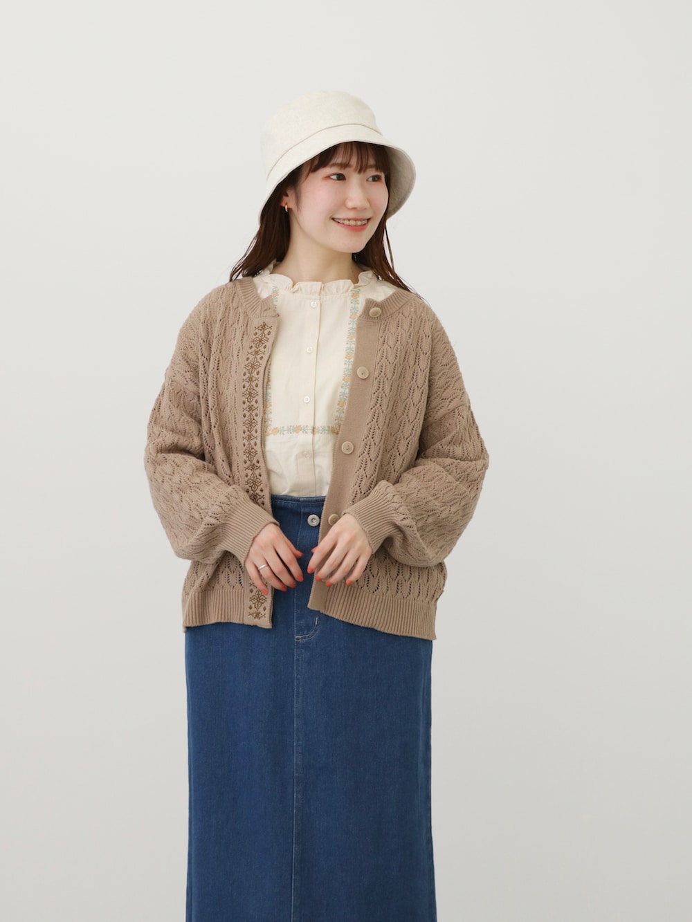 ブルー系のスカート、ブラウン系のその他シューズ、ベージュ系のカーディガン/ボレロを着用したレディースの春コーディネートの2枚目の写真