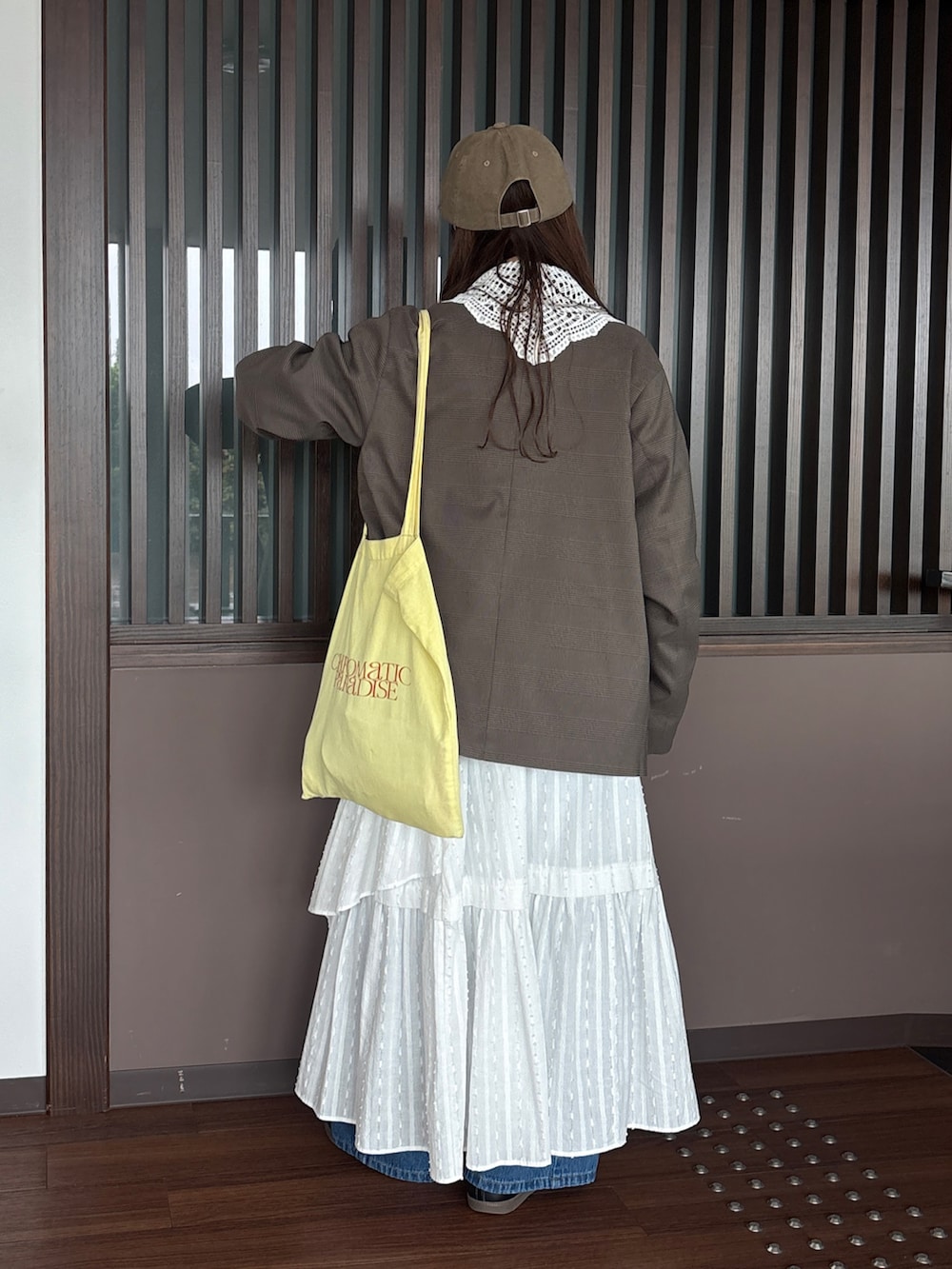 グレー系のスウェット、ブルー系のデニムパンツ、グリーン系のテーラードジャケットを着用したレディースの秋コーディネートの3枚目の写真
