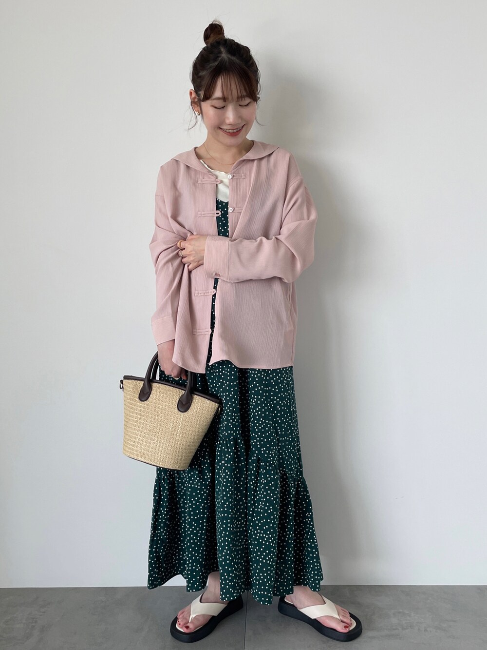 ピンク系のシャツ/ブラウス、グリーン系のワンピース、ブラウン系のハンドバッグを着用したレディースの春コーディネートの2枚目の写真