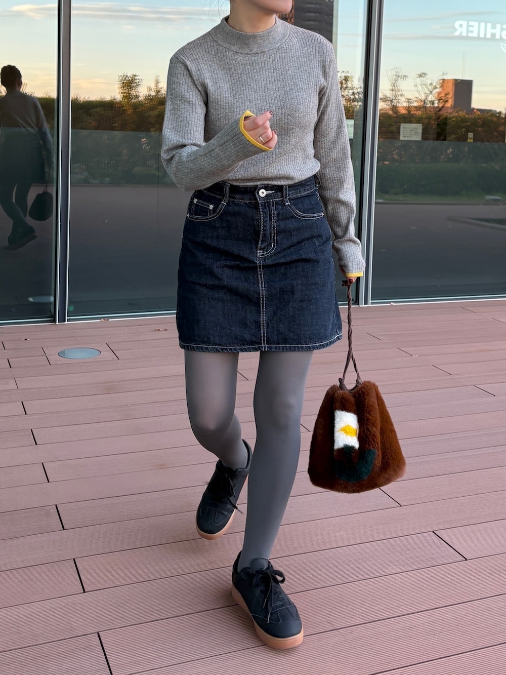 グレー系のニット/セーター、ブラック系のスニーカーを着用したレディースの秋コーディネートの3枚目の写真