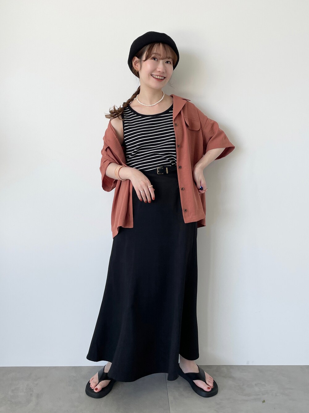 ブラック系のタンクトップ、オレンジ系のシャツ/ブラウス、ブラック系のスカートを着用したレディースの夏コーディネートの2枚目の写真