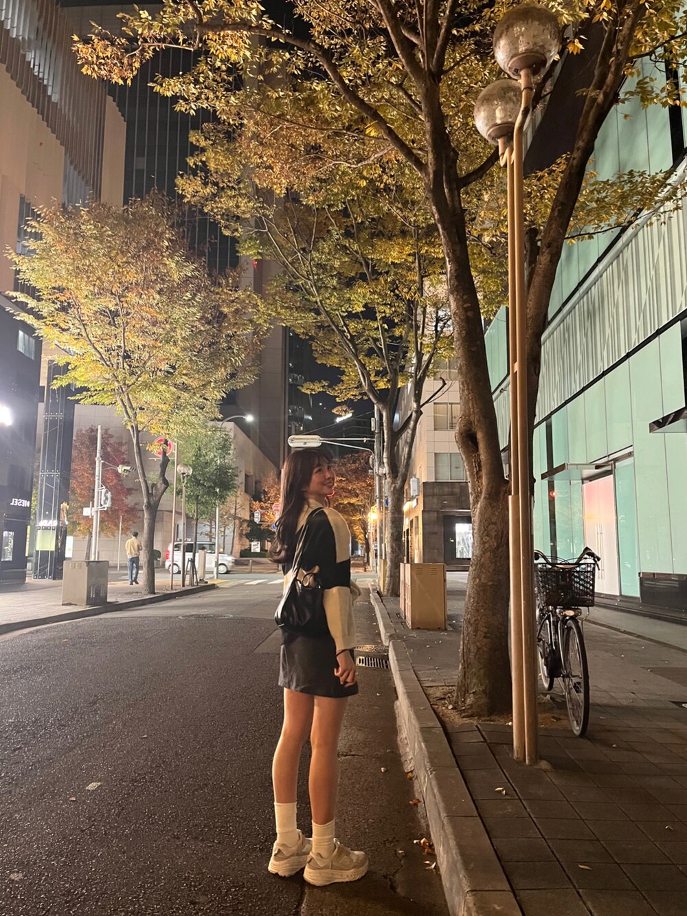 ホワイト系のニット/セーター、グレー系のスカート、ホワイト系のスニーカーを着用したレディースの冬コーディネートの3枚目の写真