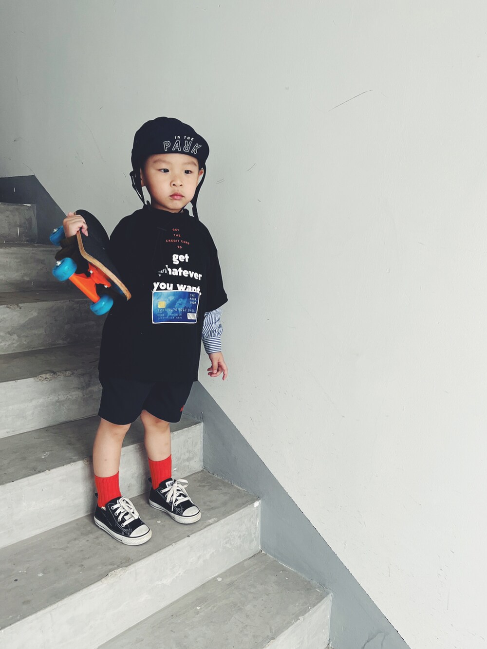 ホワイト系のスニーカー、ホワイト系のTシャツ/カットソー、ブラック系のカーゴパンツを着用したキッズの夏コーディネートの2枚目の写真