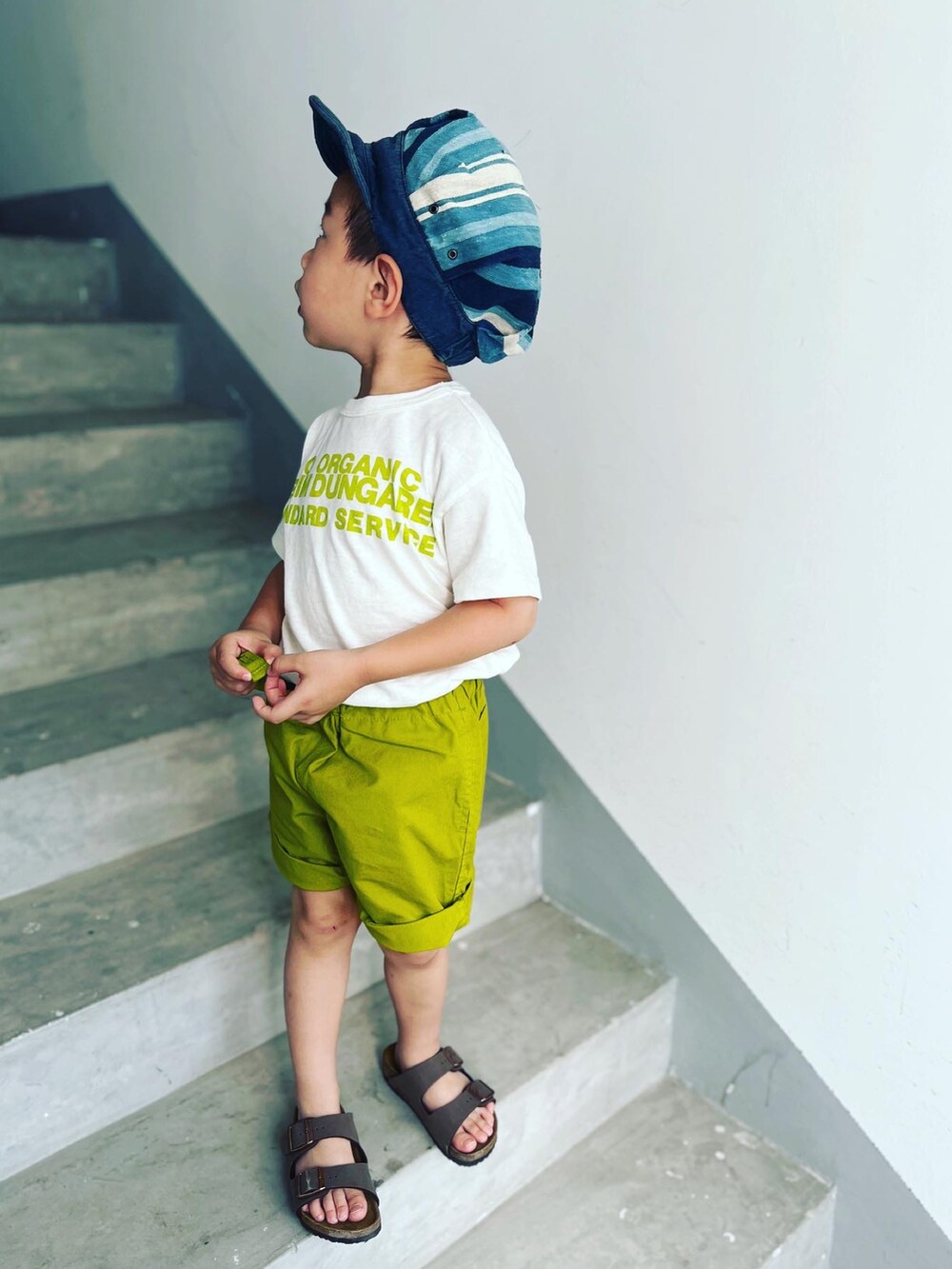 ブラウン系のサンダル、グリーン系のカーゴパンツ、ホワイト系のTシャツ/カットソーを着用したキッズの夏コーディネートの5枚目の写真