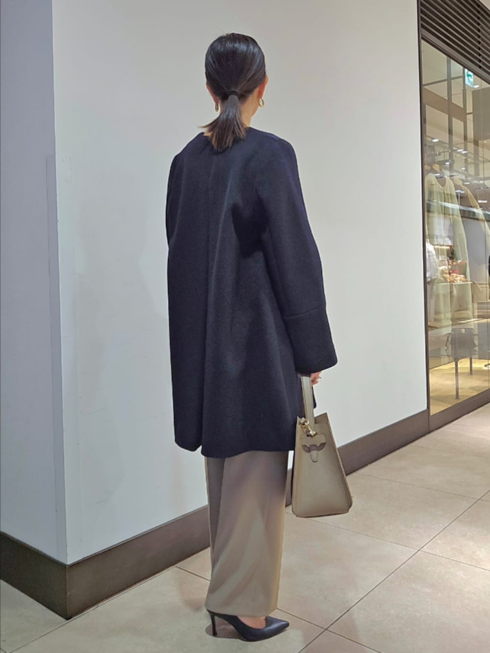 グリーン系のその他パンツ、ブルー系のノーカラーコート、ベージュ系のショルダーバッグを着用したレディースの冬コーディネートの6枚目の写真