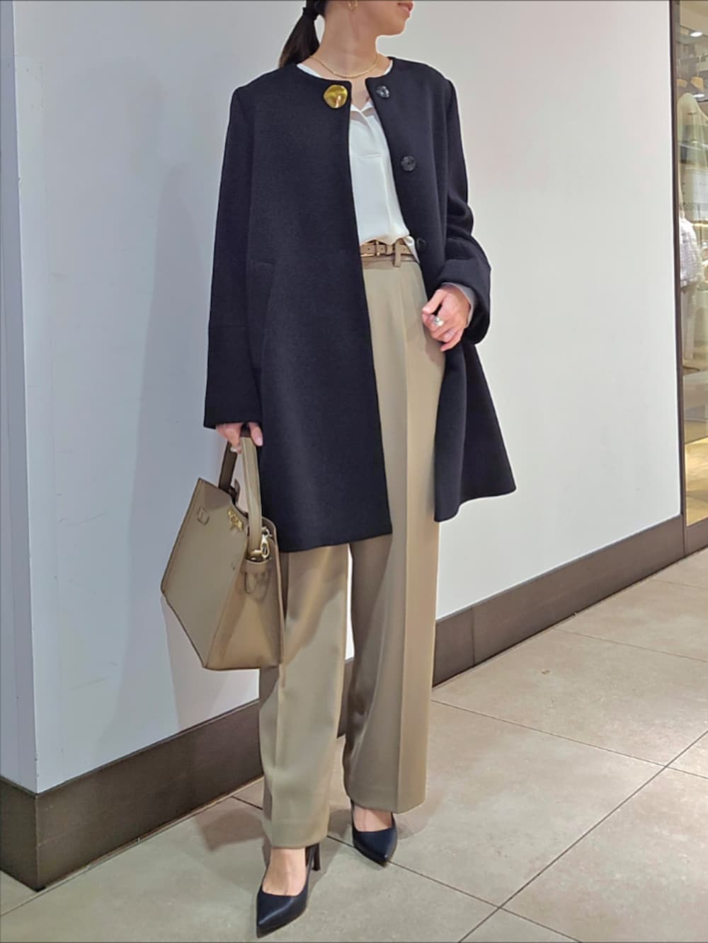 グリーン系のその他パンツ、ブルー系のノーカラーコート、ベージュ系のショルダーバッグを着用したレディースの冬コーディネートの4枚目の写真