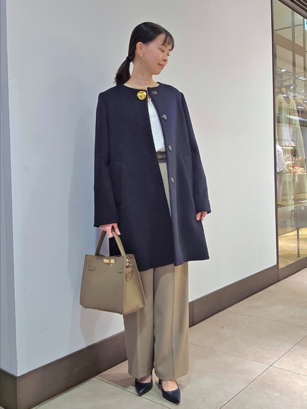 グリーン系のその他パンツ、ブルー系のノーカラーコート、ベージュ系のショルダーバッグを着用したレディースの冬コーディネートの3枚目の写真