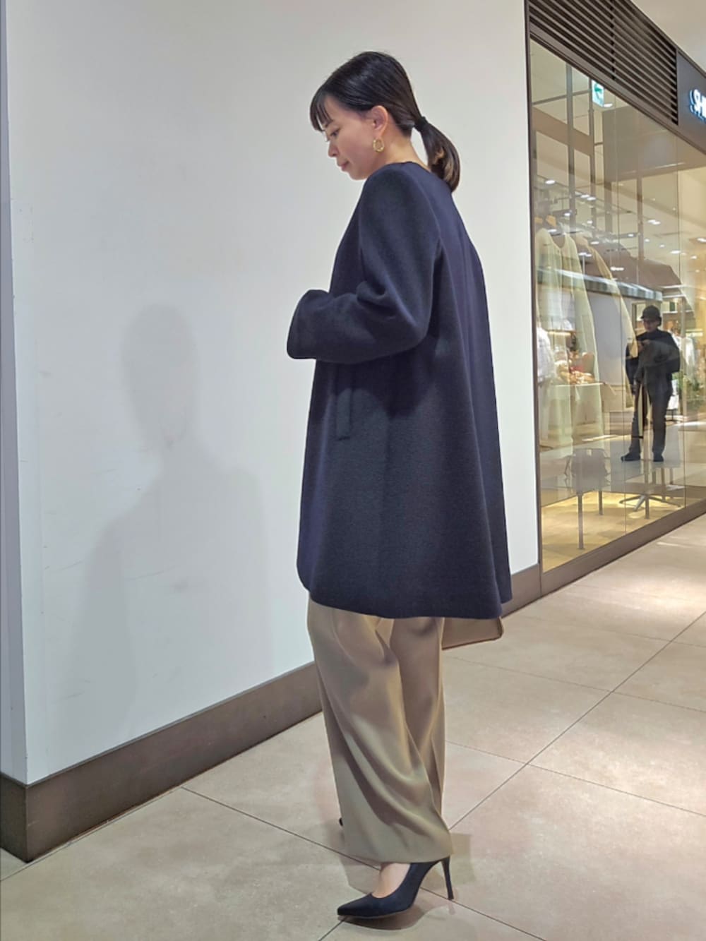 グリーン系のその他パンツ、ブルー系のノーカラーコート、ベージュ系のショルダーバッグを着用したレディースの冬コーディネートの5枚目の写真