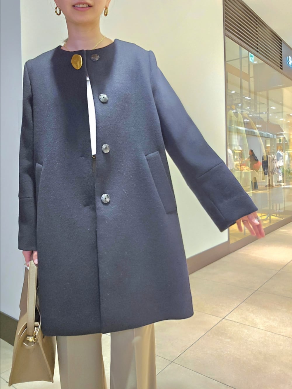 グリーン系のその他パンツ、ブルー系のノーカラーコート、ベージュ系のショルダーバッグを着用したレディースの冬コーディネートの7枚目の写真