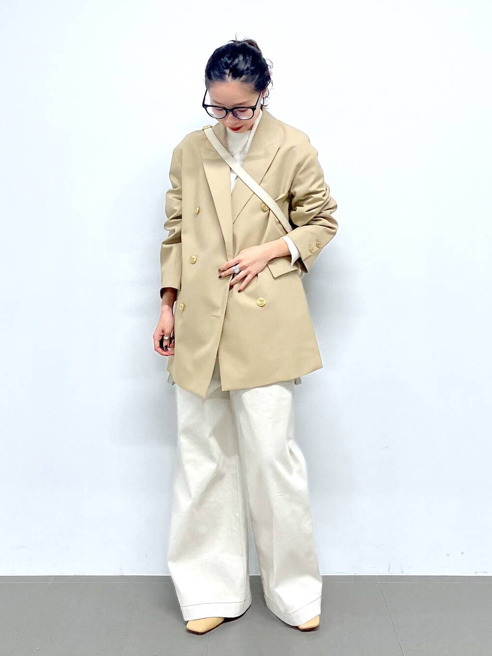 ホワイト系のショルダーバッグ、ベージュ系のテーラードジャケット、グレー系のサロペット/オーバーオールを着用したレディースの冬コーディネートの9枚目の写真