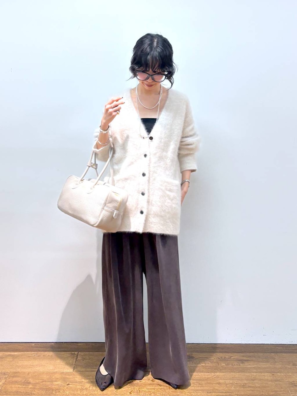 ホワイト系のカーディガン/ボレロ、ブラック系のパンプス、ブラウン系のその他パンツを着用したレディースの秋コーディネートの8枚目の写真